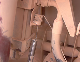 The trailing wheel hydraulic ram (left) and ride height sensor