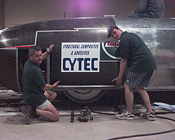 Roger and Jason McCann applying logos to the car